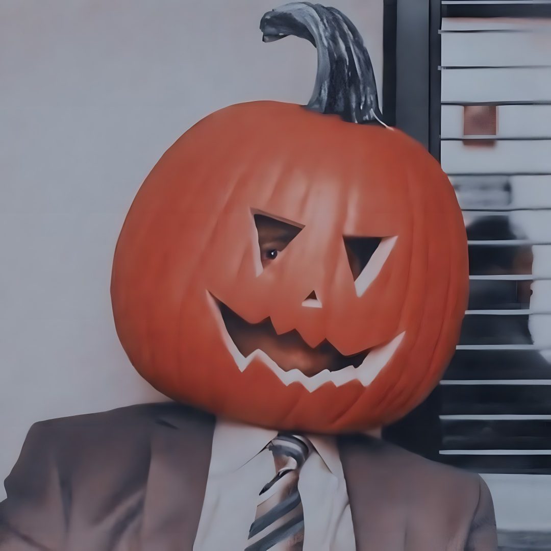 a man wearing a suit and tie with a pumpkin on his head in front of him Dwight Halloween dim gray