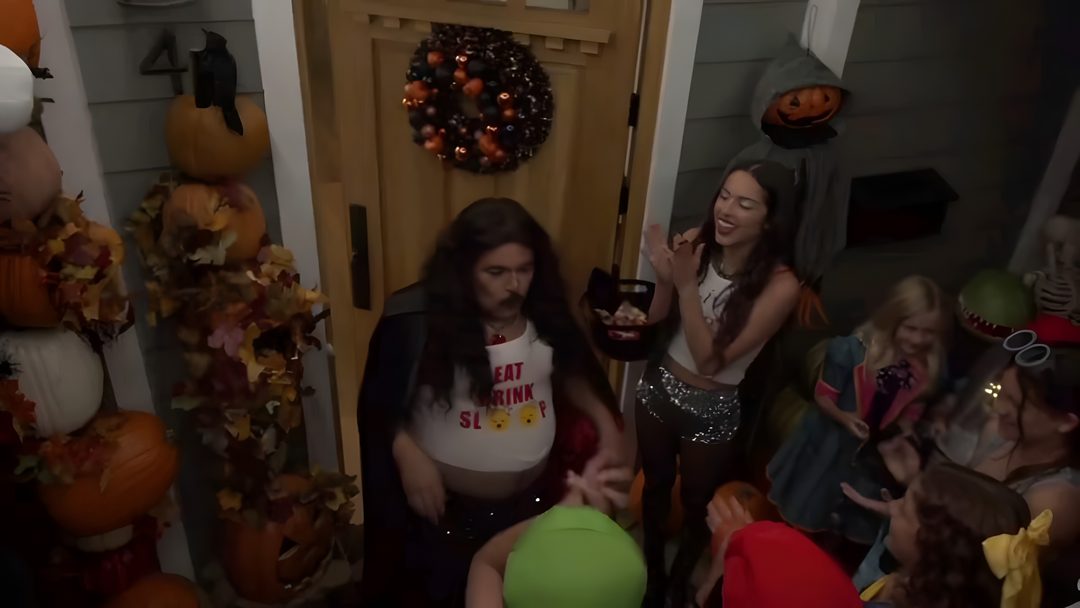 a group of people standing in front of a door with halloween decorations on the wall Halloween Olivia Rodrigo Olivia Rodrigo Snl, Bizaardvark Halloween, Olivia Rodrigo Halloween, black