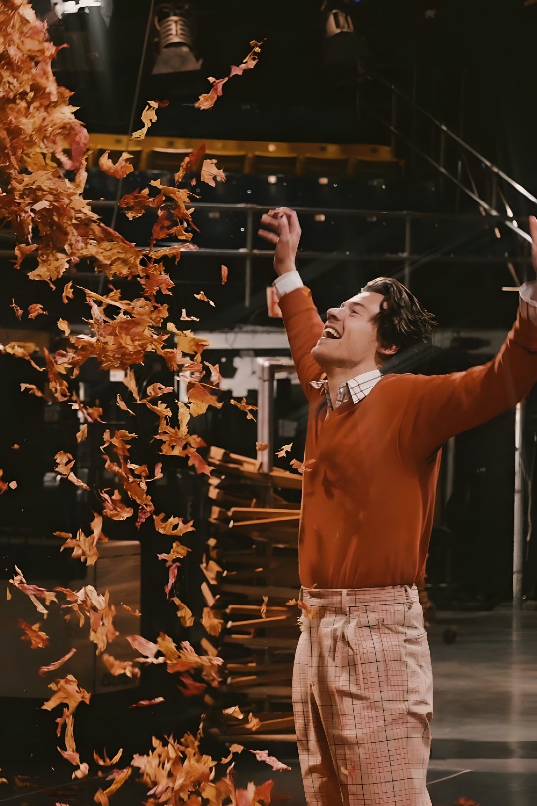 a man in red sweater throwing confetti on stage Harry Styles Halloween black