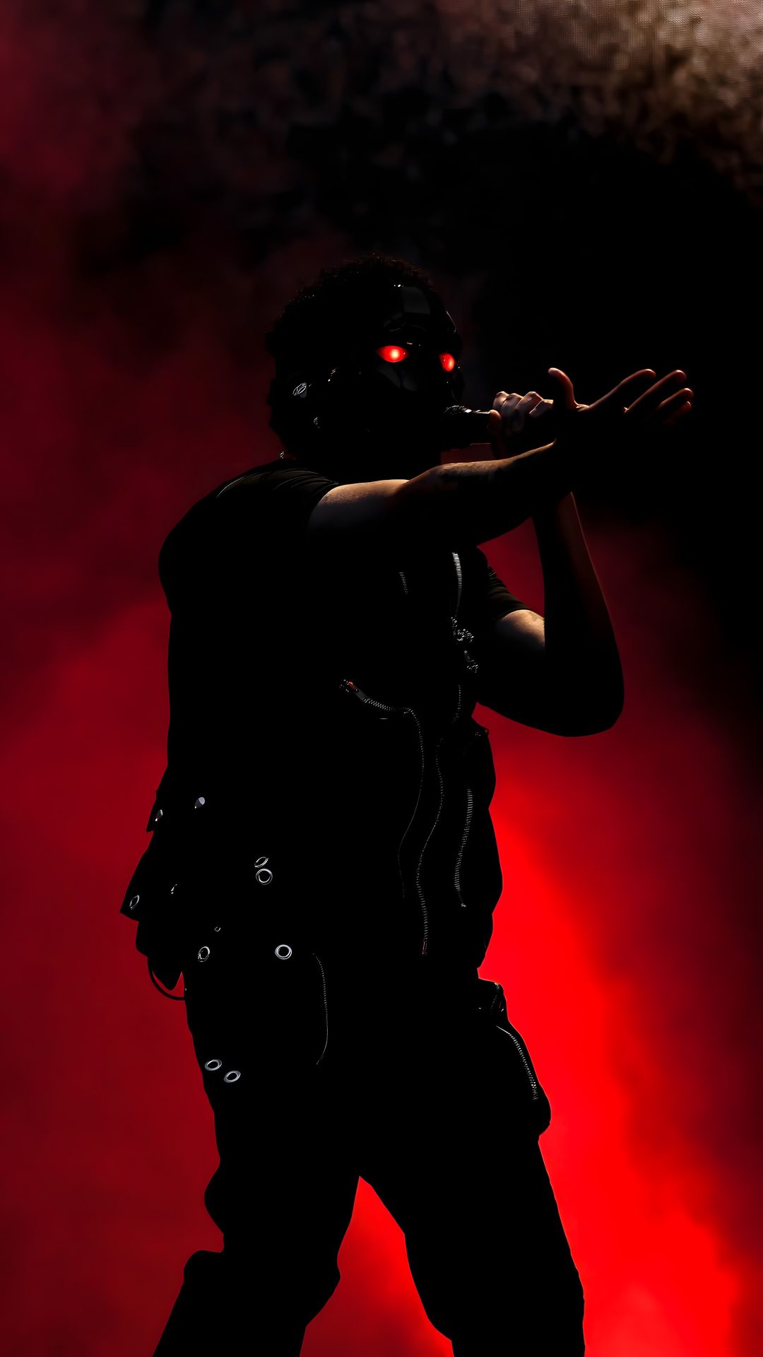 the silhouette of a man with red eyes on stage The Weeknd Halloween black