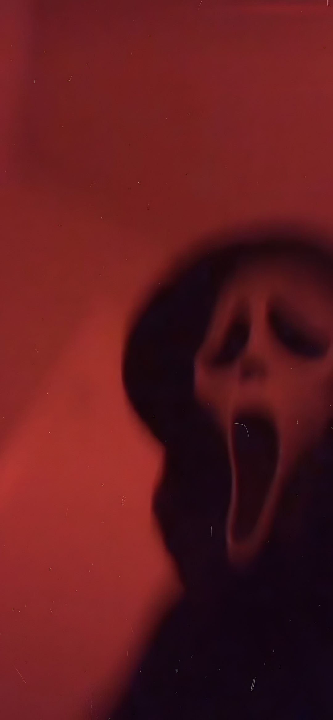a person with their mouth open in front of a red wall Halloween Ios16 maroon