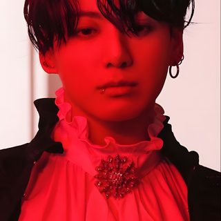 a woman with short black hair wearing a red shirt and earrings, standing in front of a white wall Jungkook Halloween Jungkook Photoshoot Me Myself, Jungkook Me Myself And I Photocards, Me Myself And Jungkook, crimson