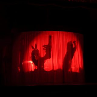 the shadow of two people on a red curtain in front of a stage with lights Sabrina Carpenter Halloween Sabrina Carpenter Act 1, Sabrina Carpenter Red Curtain, Short N Spooky Sabrina Carpenter, black