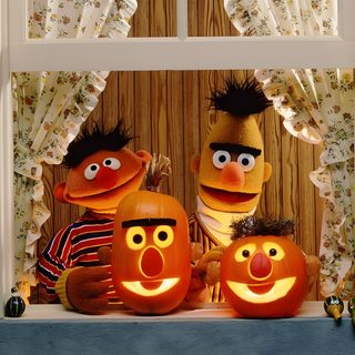 two sesame street characters with carved pumpkins in front of a window, one holding a lit candle Muppets Halloween Sesame Street Pumpkin Carving, Sesame Street Pumpkins, Bert Ernie Pumpkins, sienna