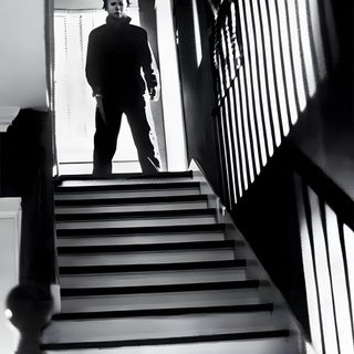 a man standing on top of a set of stairs Halloween 1978 Michael Myers Standing In Shadows, Michael Myers Stairs, Michael Myers In Shadow, dark slate gray