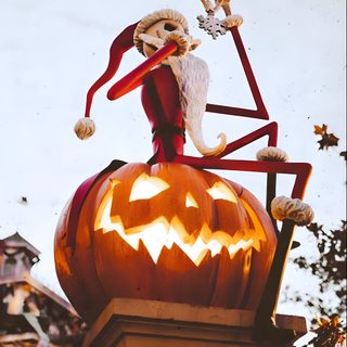 a statue of a skeleton sitting on top of a pumpkin in front of a sky background Walt Disney World Halloween Halloween Iphone Nightmare Before Christmas, Fall Aesthetic Nightmare Before Christmas, Halloween Town Nightmare Before Christmas, silver