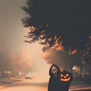a person wearing a jack o lantern mask standing on the side of a road at night Aesthetic Edgy Aesthetic Halloween Halloween Movies List, Future, Scary, dark olive green
