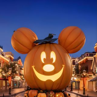 a mickey mouse pumpkin in the middle of a street Disneyland Halloween Aesthetic dark slate gray