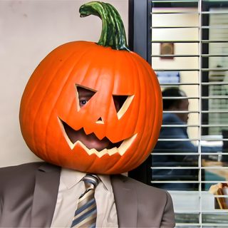 a man in a suit and tie with a pumpkin on his head, sitting at a table Dwight Halloween Dwight Pumpkin Head, Pumpkin Dwight, The Office Pumpkin, rosy brown