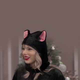 lady in black cat costume with pink ears on her head and hands folded out to the side Taylor Swift Halloween Taylor Swift Halloween Pictures, Halloween Taylor Swift, Taylor Swift Cat Photo, dim gray