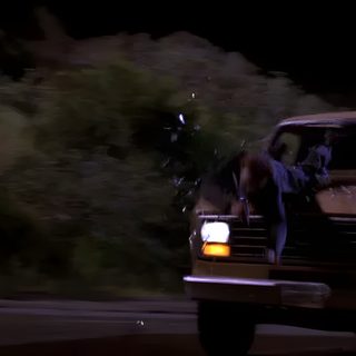 a truck driving down a street at night with the door open and two people in it Halloween H20 black