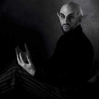 a bald man sitting on top of a bed wearing striped pants and holding his hands in the air Bad Bunny Halloween What We Do In The Shadows Nosferatu, Nosferatu Ears, Nosferatu Cosplay, black