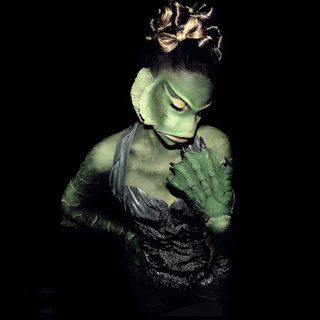 a woman with green makeup and hands on her face, in front of a black background Ariana Grande Halloween Ariana Halloween Costume, Ariana Grande Twilight Zone Costume, Ariana Grande Halloween Pfp, black