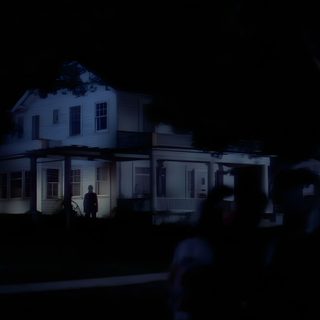 a house lit up at night with people walking in the front yard and on the sidewalk Halloween 1978 4k Halloween 1978 Halloween 1978 Michael Myers House, Halloween 1978 4k, Halloween 1978 Background, black