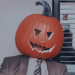 a man wearing a suit and tie with a pumpkin on his head in front of him Dwight Halloween dim gray