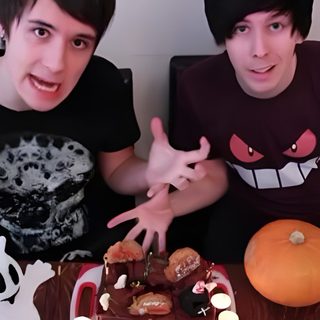 two young men sitting next to each other in front of a table with food on it Dan And Phil Halloween 2009 Dan And Phil Halloween Baking, Phil Lester Halloween, Dan And Phil 2012, dim gray