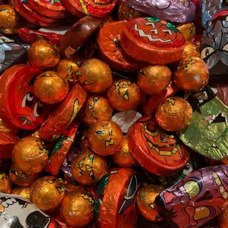 there are many candy candies in the pile together with faces painted on each one Halloween Candy Old Halloween Candy, British Halloween, Retro Halloween Aesthetic, saddle brown