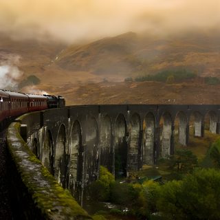a train traveling over a bridge in the mountains Halloween Train Harry Potter Background Laptop Aesthetic, Hogwarts Mountain, Laptop Hd 1080p Aesthetic Harry Potter, dark olive green