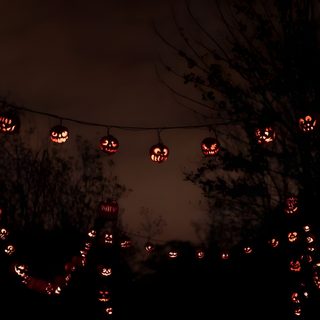 many pumpkins are lit up in the night sky and on wires, with trees behind them Halloweencore Halloween Sky Aesthetic, Halloween Aesthetic Computer, Halloween Header, black