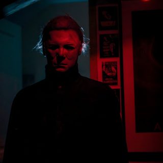 a man is standing in the dark with his head turned to the side and looking at the camera Halloween Michael Myers Iphone Michael Myers Art, Halloween Franchise, Halloween Film, black