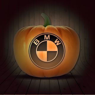 an illuminated pumpkin with the bmw logo on it's front and side, sitting on a wooden floor Bmw Halloween Bmw Autumn Drive, Bmw Logo Png, Bmw Logo Art Design, Bmw Christmas Decorations, black