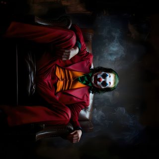a man in a red suit and clown makeup is holding a soccer ball while sitting on a chair Juvea Halloween 4k black