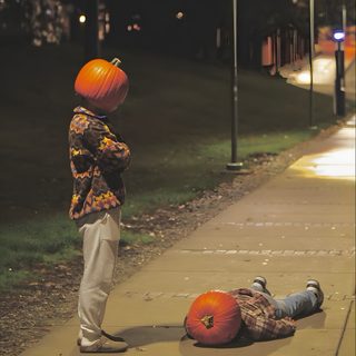 a young boy standing next to an orange pumpkin on the sidewalk with another person laying down Aesthetic Halloween Boys Halloween Kürbis Schnitzen, Halloween Photography, Have Inspiration, dark olive green