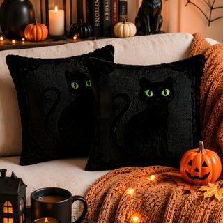 two black cat pillows sitting on top of a couch next to candles and pumpkins Halloween Black Cat Pillow maroon