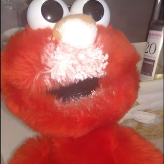a red stuffed animal with big eyes and googly eyes Elmo Halloween Creative Elmo-themed Party, Elmo With Powdered Sugar, Elmo With Powdered Sugar On Face, sienna