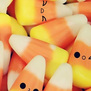 there are many candy corn with faces drawn on the top one is orange and white Halloween Candy Corn Candy Corn Background Aesthetic, Cute Candy Corn Aesthetic, Candy Corn Black Background, sandy brown
