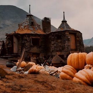 pumpkins are piled on the ground in front of an old house with mountains in the background Hogwarts Halloween Desktop Hagrids Hut, Hagrid Aesthetic, Hagrid Hogwarts Grounds, Imac, saddle brown