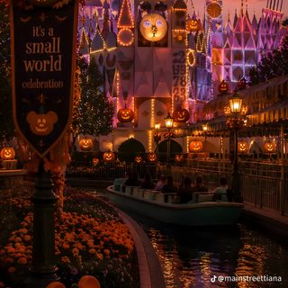 the entrance to disneyland world at night with pumpkins and jack - o'- lanterns Iphone Disneyland Halloween maroon