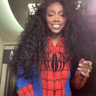 a woman with long curly hair wearing a spiderman shirt and holding a cell phone Sza Halloween Sza Bow, Sza Halloween Custome, Sza Catwoman, Sza Pfp Funny, Sza Icons Funny, dark olive green