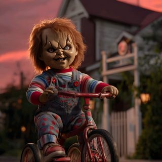 a creepy doll is riding a tricycle down the street at dusk with a house in the background Chucky Halloween Scary Chucky, Chucky 4k Iphone, Chucky Scary, 4k Chucky, Chucky Doll Iphone, dark olive green