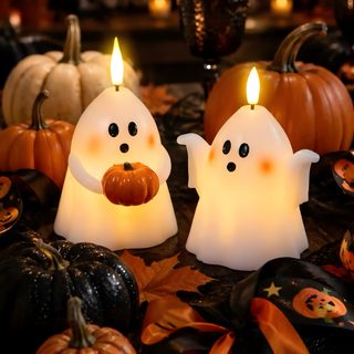 two candles with ghost faces and pumpkins on the table in front of some lights Halloween Candle maroon