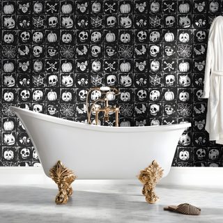 a white bath tub sitting next to a black and white wall with skulls on it Halloween Themed Bathroom dark gray