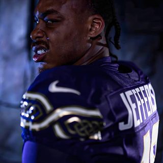 a football player with dreadlocks is posing for a photo in the dark room Justin Jefferson Halloween black