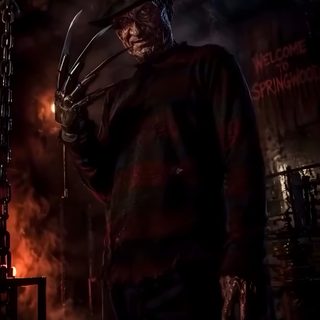 a man in a creepy mask and hat standing next to a chain link fence at night Halloween Freddy Kruger black