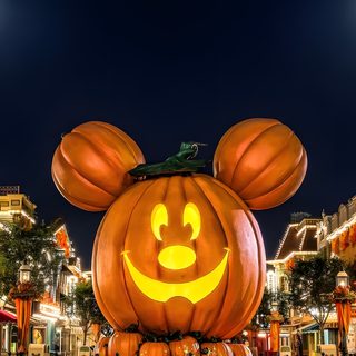 a mickey mouse pumpkin in the middle of a street with buildings and lights behind it Disneyland Halloween Halloween Iphone, Halloween, Halloween Desktop, Disney Mignon, Photo Halloween, black