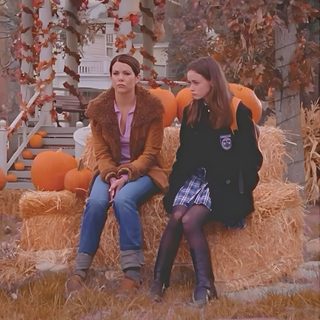 two women sitting on a hay bale with pumpkins in the background Gilmore Girls Halloween Deco Surf, Gilmore Girl, Gilmore Girls Seasons, Lauren Graham, sienna