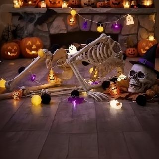 a skeleton laying on the floor surrounded by halloween decorations Halloween Skeleton Party dark slate gray