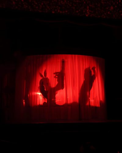 the shadow of two people on a red curtain in front of a stage with lights Sabrina Carpenter Halloween Sabrina Carpenter Act 1, Sabrina Carpenter Red Curtain, Short N Spooky Sabrina Carpenter, black