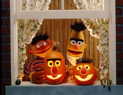 two sesame street characters with carved pumpkins in front of a window, one holding a lit candle Muppets Halloween Sesame Street Pumpkin Carving, Sesame Street Pumpkins, Bert Ernie Pumpkins, sienna