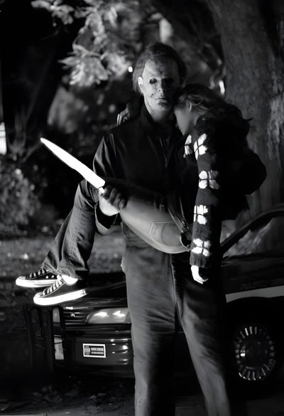 a man and woman standing next to each other in front of a car at night Halloween 2007 Michael Myers Jason Voorhees, Halloween 2007, Jason And Michael Myers, Michael Myers Hug, black