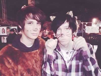 two young men standing next to each other in front of a crowd with fake cats on their faces Dan And Phil Halloween 2009 Dan And Phil Halloween, Dan Howell 2010, Phan Proof, Dan And Phil Makeup, dim gray