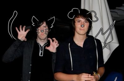 two young men standing next to each other in front of a flag with cats drawn on it Dan And Phil Halloween 2009 Dan And Phil, black