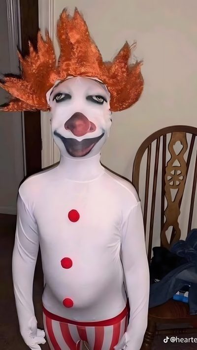 a clown with orange hair and red pants is standing in front of a chair wearing a white body suit Goofy Ahh Halloween Skeleton Hand Drawing Tutorial, Halloween Pictures To Draw, Clowns Funny, rosy brown