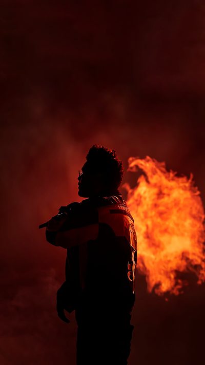 a man standing in front of a fire with his back to the camera and arms around him The Weeknd Halloween The Weeknd Background, The Weeknd Iphone, The Weeknd Albums, Starboy The Weeknd, black