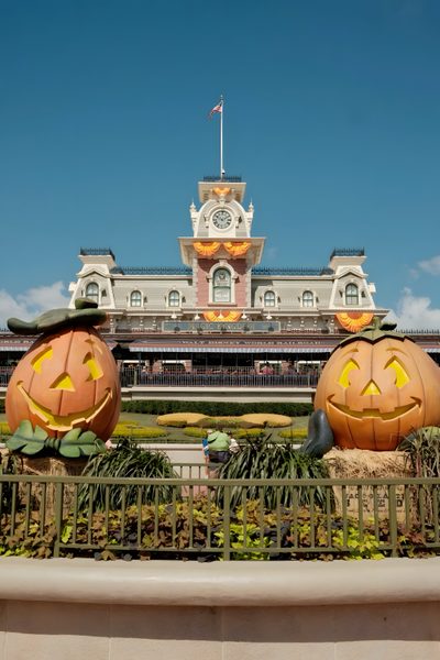two carved pumpkins in front of a building with a clock tower on the top Disney World Halloween Pumpkin, Disneyland Pumpkin, Disney World Halloween, slate gray