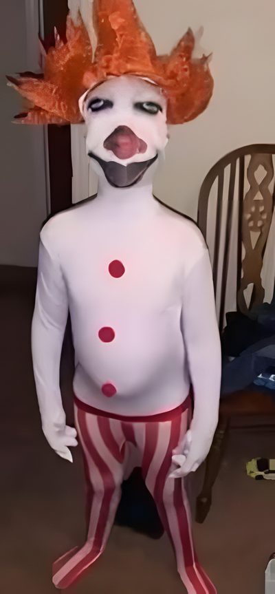 a person in a clown costume standing on the floor Goofy Ahh Halloween Clown Costume With Orange Wig, Colorful Clown Outfit, Diy Clown Costume Ideas, sienna